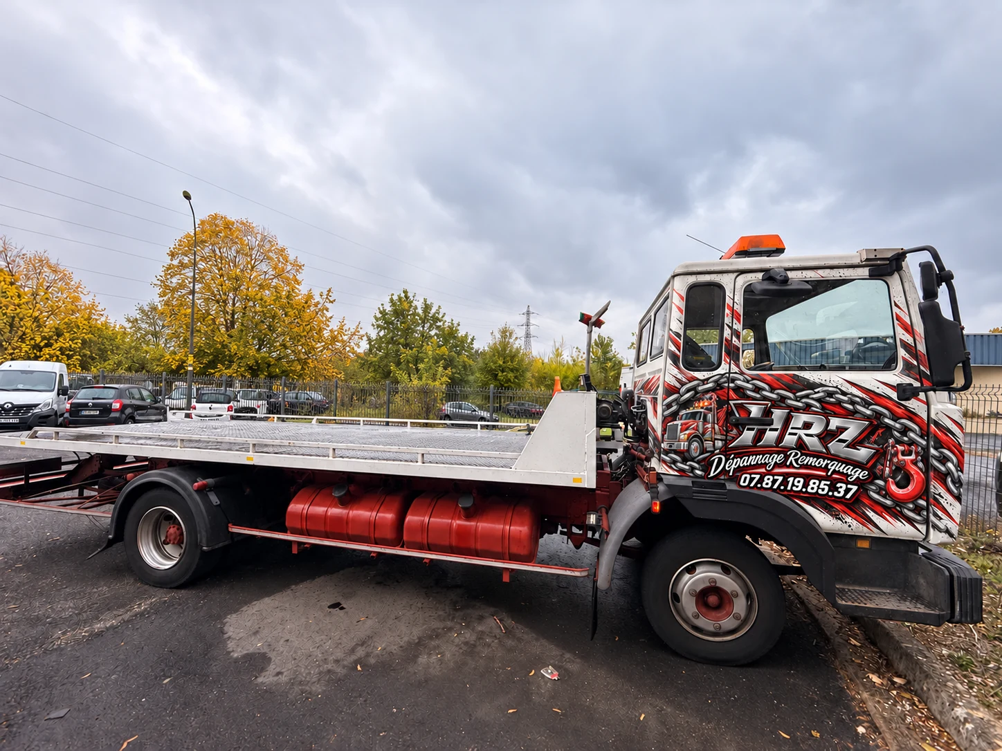 Dépanneuse Renault Midliner HRZ avec plateau vide et flocage rouge, noir et argent